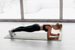 © MZaitsev - Athletic woman doing plank exercise in white sunny gum