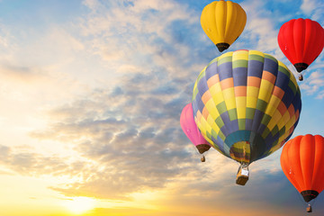 Colorful balloons floating in the sky at sunset.