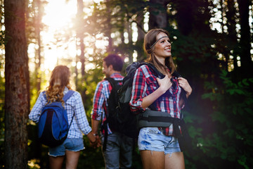 Wall Mural - beautiful woman and friends hiking in forest