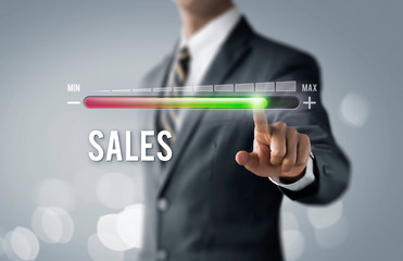 Sales growth, increase sales or business growth concept. Businessman is pulling up progress bar with the word SALES on bright tone background.