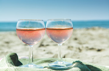 Beach party with sea view, romantic celebration on sunny sandy beach, two glasses with rose wine