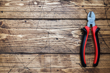 Pliers tongs on wooden background with copy space. Repair tools.