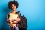 Fototapeta  - young african student with backpack on the back on blue background