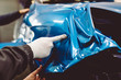 © hedgehog94 - Car wrapping specialist putting vinyl foil or film on car. Selective focus.