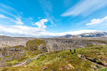 Snaefellsjokull, Iceland national park with people on trail to Djupalonssandur Beach Hellnar and green grass landscape