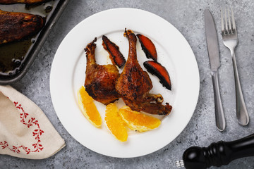 Baked duck with oranges in a white plate on the table