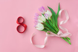 Fototapeta Tulipany - Bouquet of tulips on a pink pastel background. Wonderful spring breakfast on Mother's Day or Women. Flat lay. View top. Selective focus.