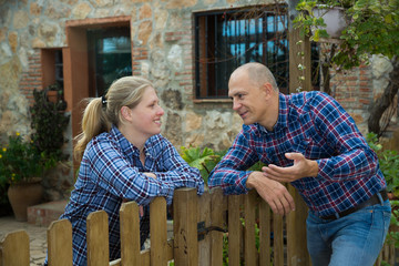 man and woman communicate in a friendly way on the border of their farms