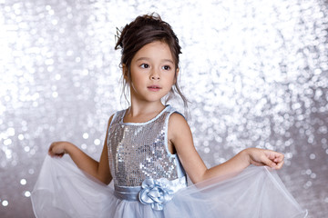 cute smiling little child girl in silver and blue dress