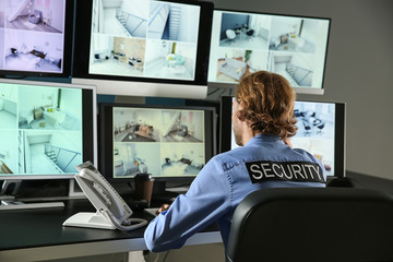 Sticker - Security guard monitoring modern CCTV cameras in surveillance room