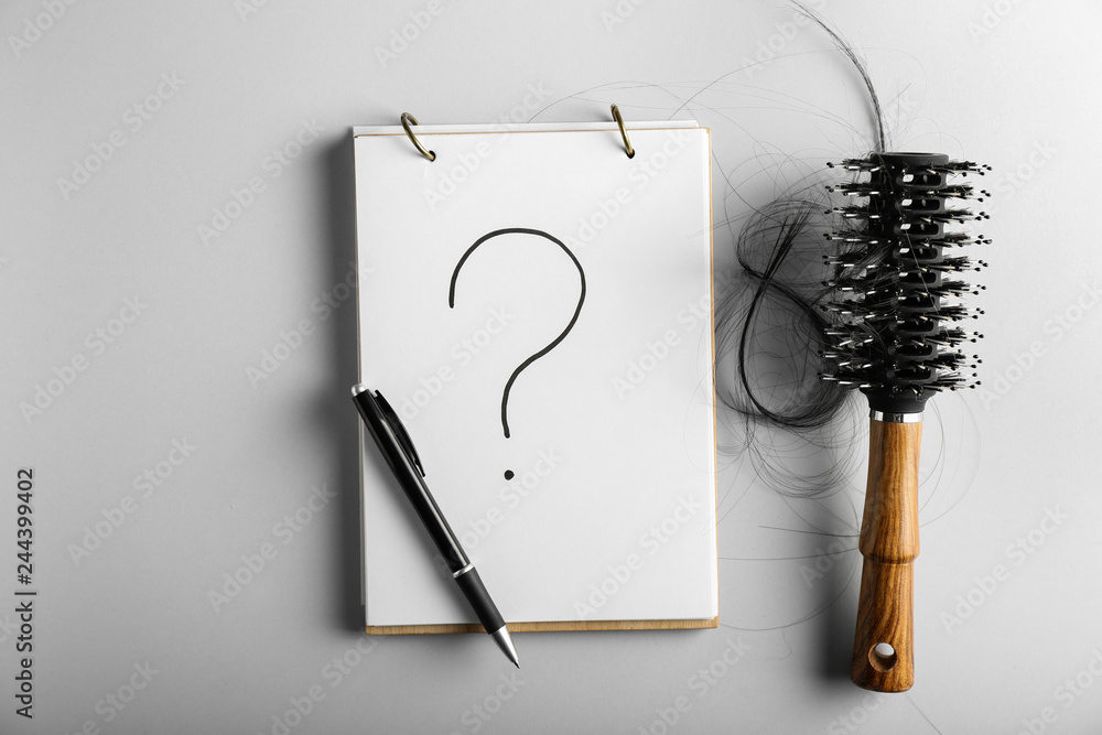 Composition with notebook and hair brush on grey background