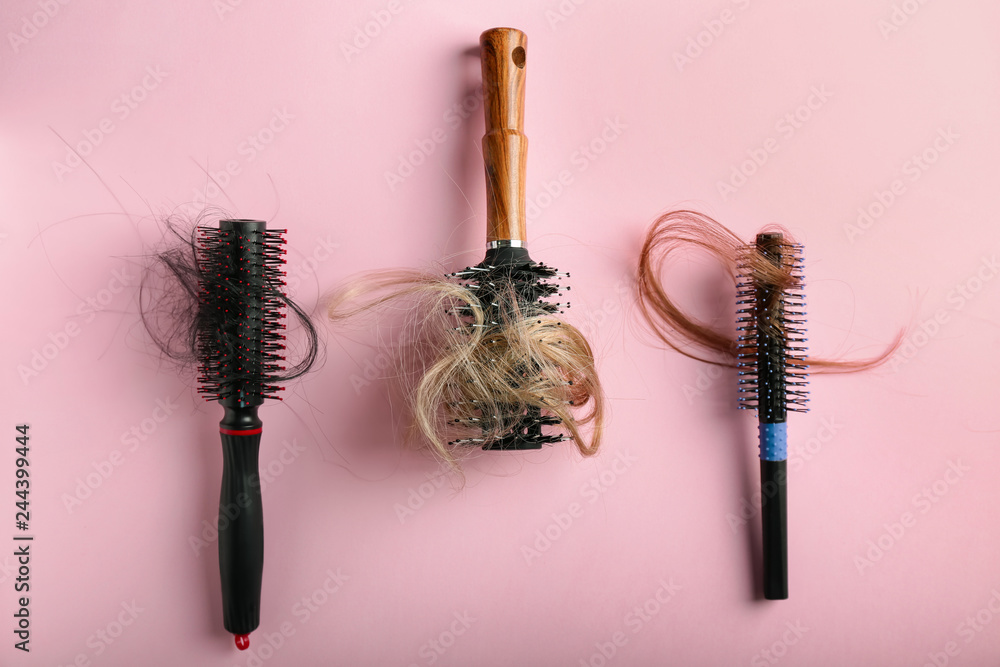 Brushes with fallen down hair on color background