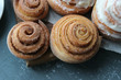 © Александра Ермоленко - Beautiful fresh cinnamon rolls close-up on wooden grunge texture table. Fragrant homemade cakes, Cinnabon. A Cup of tea on a white saucer, cinnamon sticks. Delicious Breakfast buffet.