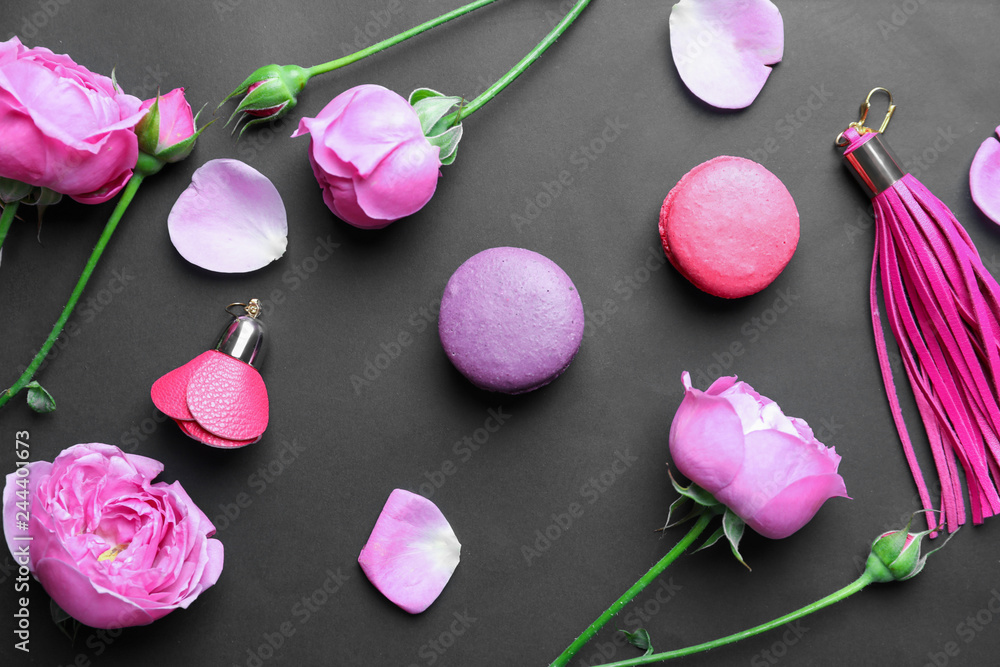 Composition with flowers, macarons and accessories on dark background