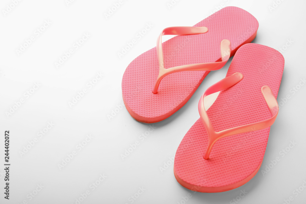 Coral flip flops on white background