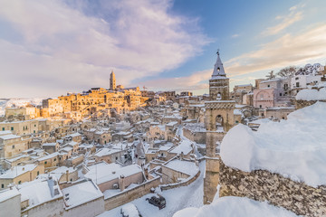 panoramic view of typical stones Sassi di Matera and church of Matera 2019 under blue sky with clouds and snow on the house, concept of travel and christmas holiday,capital of europe culture 2019