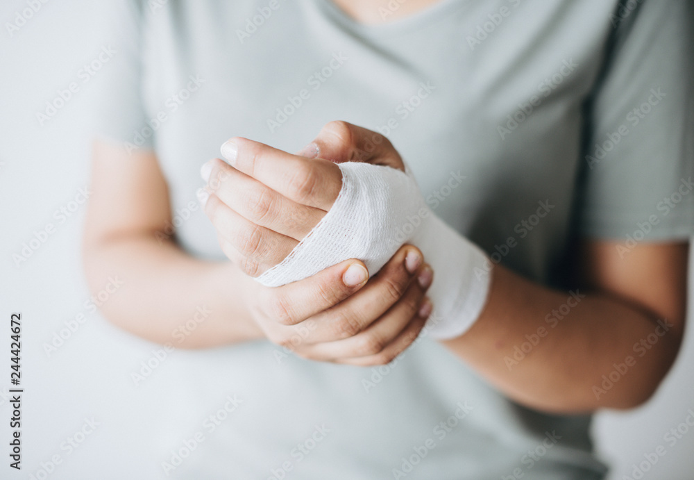 Woman with gauze bandage wrapped around her hand - obrazy, fototapety, plakaty 