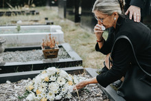 Old Woman Laying Flowers On A Grave