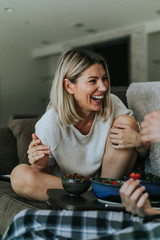 Cheerful woman talking with her boyfriend on the couch