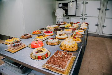 many cakes prepared on the metal table of a food factory