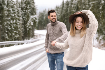 Poster - Couple walking near snowy forest, space for text. Winter vacation