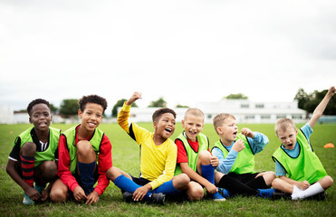 Wall Mural - Enthusiastic football players sitting on the field