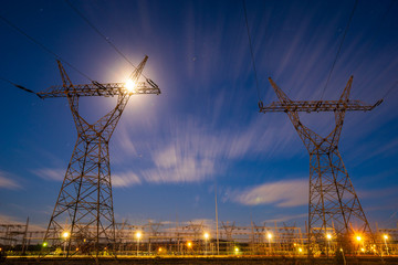 Wall Mural - high-voltage power lines and high voltage electric transmission tower in the light of the full moon