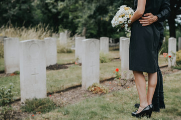 Wall Mural - Couple standing together by a gravestone