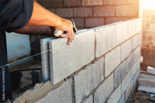 Fotomural Worker building wall bricks with cement