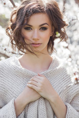 Close up portrait of young beautiful woman on spring background. Attractive young girl with flowers. Spring make up model.