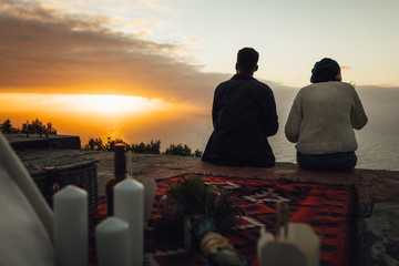 Wall Mural - couple having picnic looking at sunset