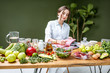 © rh2010 - Woman dietitian in medical uniform working on a diet plan sitting with different healthy food ingredients in the green office