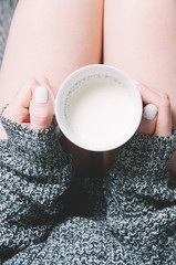 Wall Mural - Woman holding a mug of milk in her hands. Top view