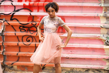 Canvas Print - Street fashion. Portrait of an African young woman in pink dress