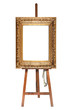 Painter's easel and empty antique golden frame