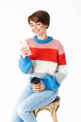 Sticker - Happy cheerful girl wearing sweater sitting on a chair