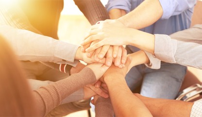 Group of people stacking hands together