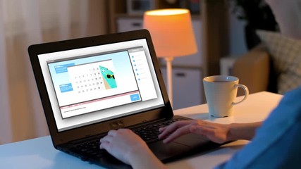 communication, technology and people concept - woman chatting online on laptop using messenger app at home at night