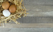 Chicken eggs in nest with burlap over wooden background