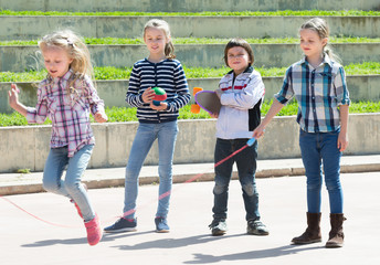 Wall Mural - Laughing girl jumping while jump rope game