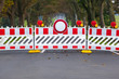 Closed Forbidden Road / Red and white colored street barrier on closed avenue road at countryside, grey asphalt copy space background