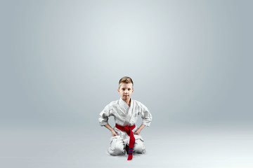 Creative background, baby in white kimono on a light background. The concept of martial arts, karate, sports since childhood, discipline.