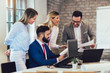 © Mediteraneo - Business colleagues working on laptop in modern office.