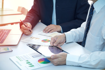 Wall Mural - Businessman is deeply reviewing a financial reports for a return on investment or investment risk analysis on a laptop computer notebook.