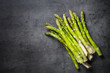 Fresh green asparagus on black slate background.