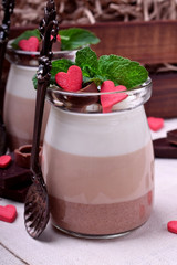 Wall Mural - Three chocolate mousse dessert in a glass jar garnished with sugar hearts and mint