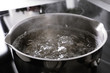 Pot with boiling water on stove, closeup