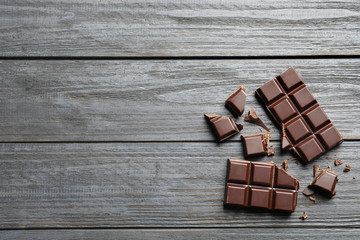 Wall Mural - Tasty chocolate on wooden background, flat lay. Space for text