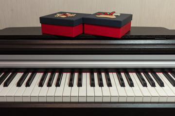 Two red gift boxes on the piano. Concept of congratulations and music.