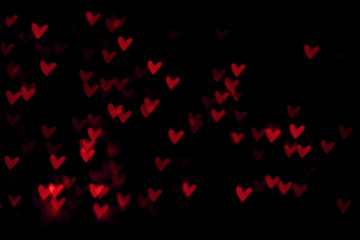 Red heart valentine bokeh lights against a black background